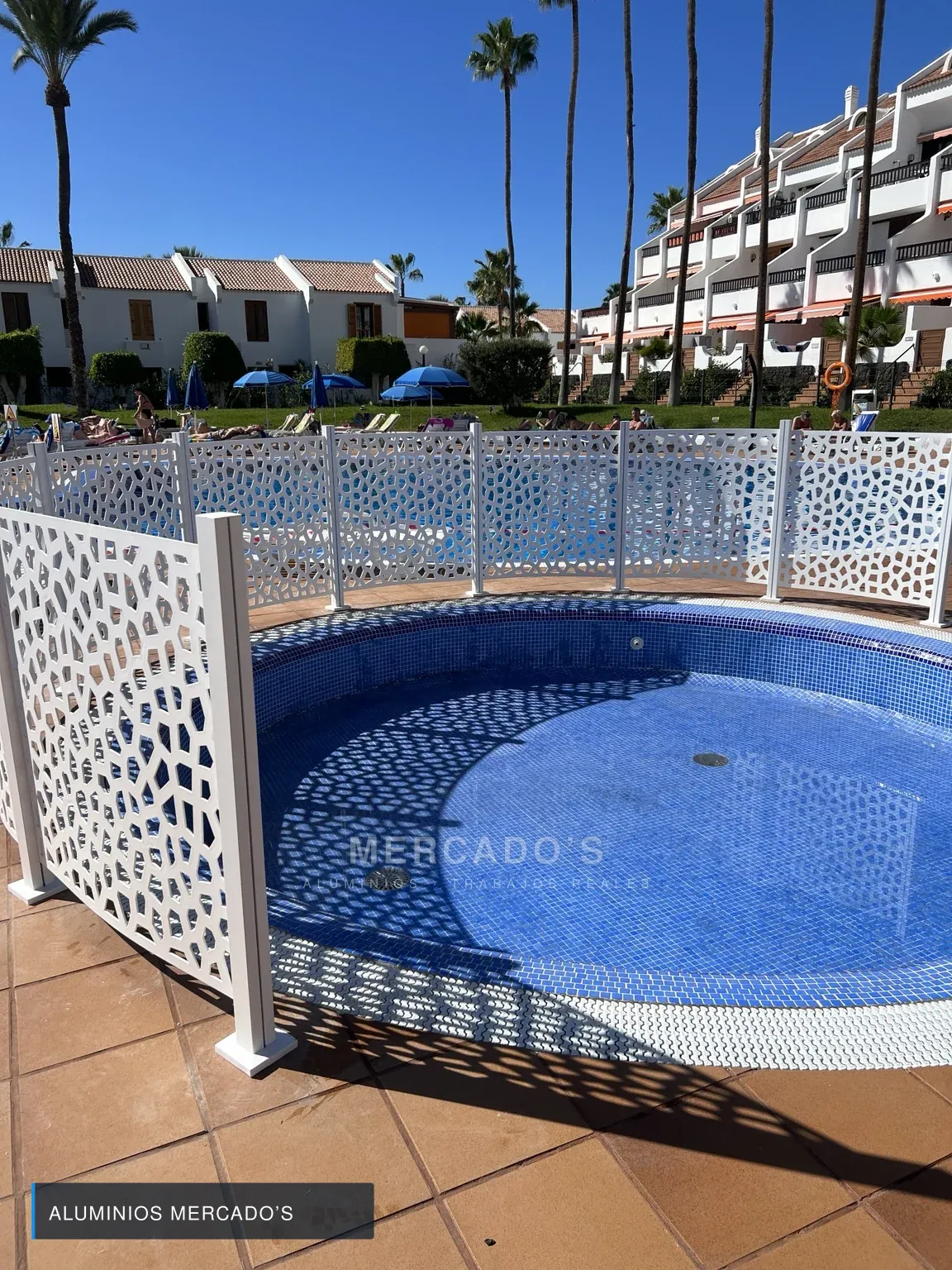Vallado blanco decorativo siguiendo el perímetro de una piscina